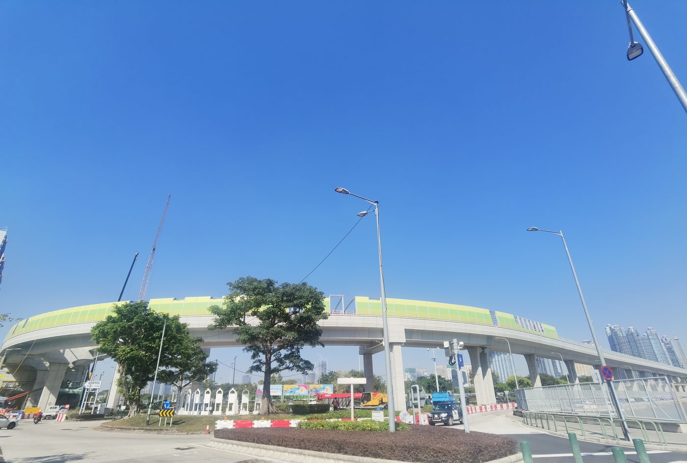 Street-level view of an elevated bridge with a curved noise barrier