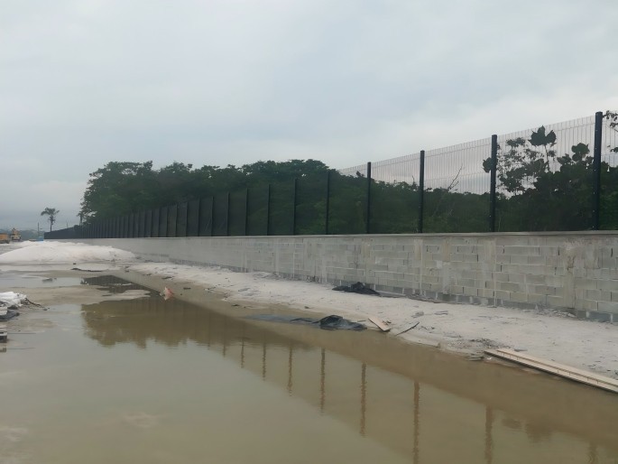 Anti-climb welded mesh security boundary fence on a concrete block wall at a site in Guyana